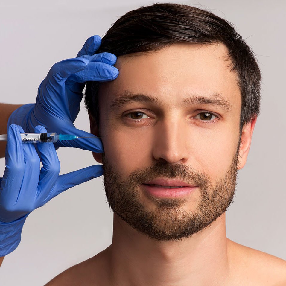 Male Injective Cosmetology. Middle Aged Man Receiving Wrinkle-Removing Injection Over White Studio Background.